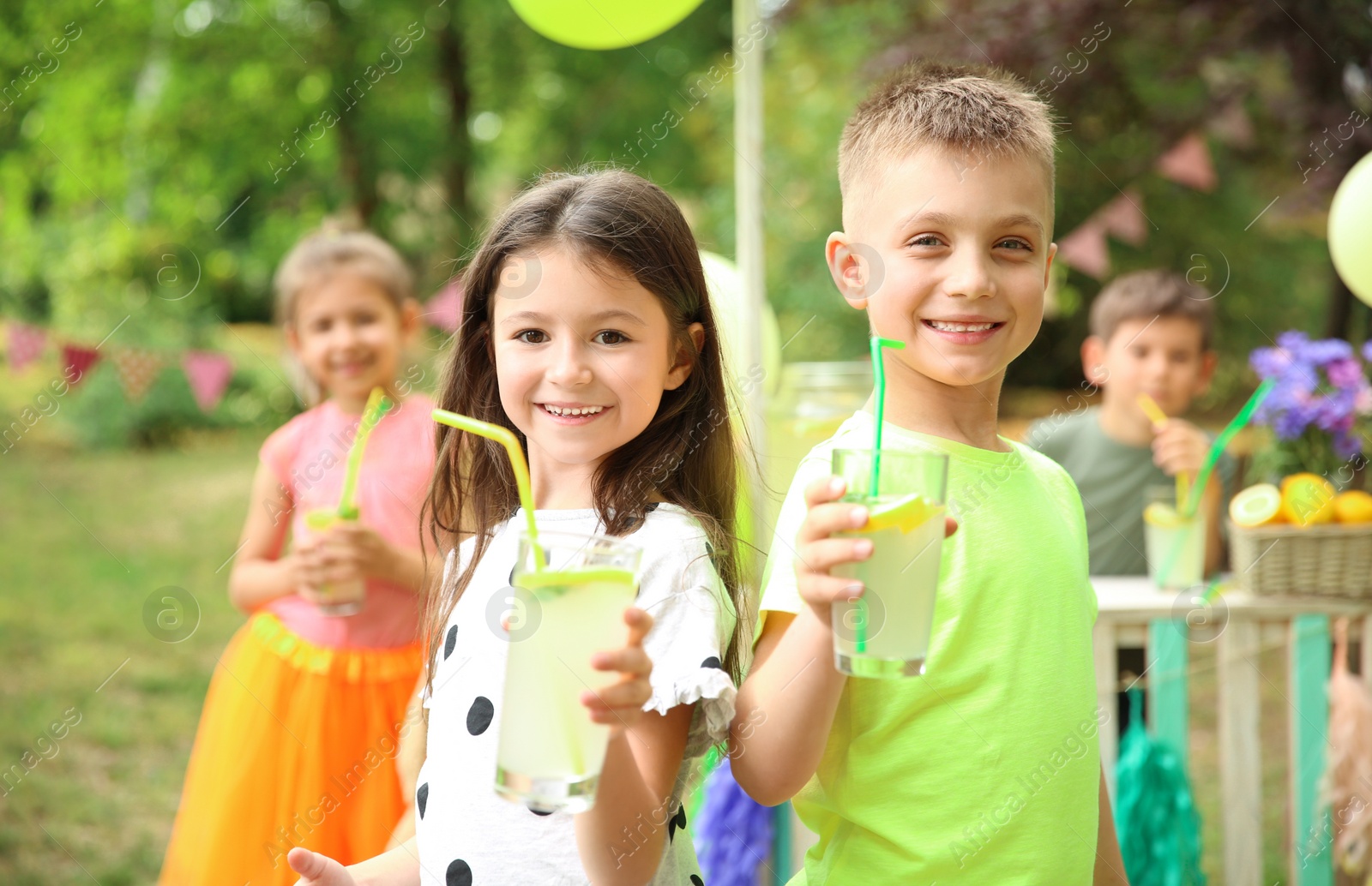 Photo of Little children with natural lemonade in park