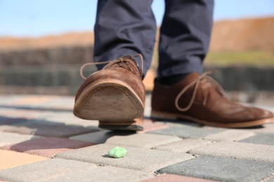 Man stepping in chewing gum on sidewalk. Concept of stickiness