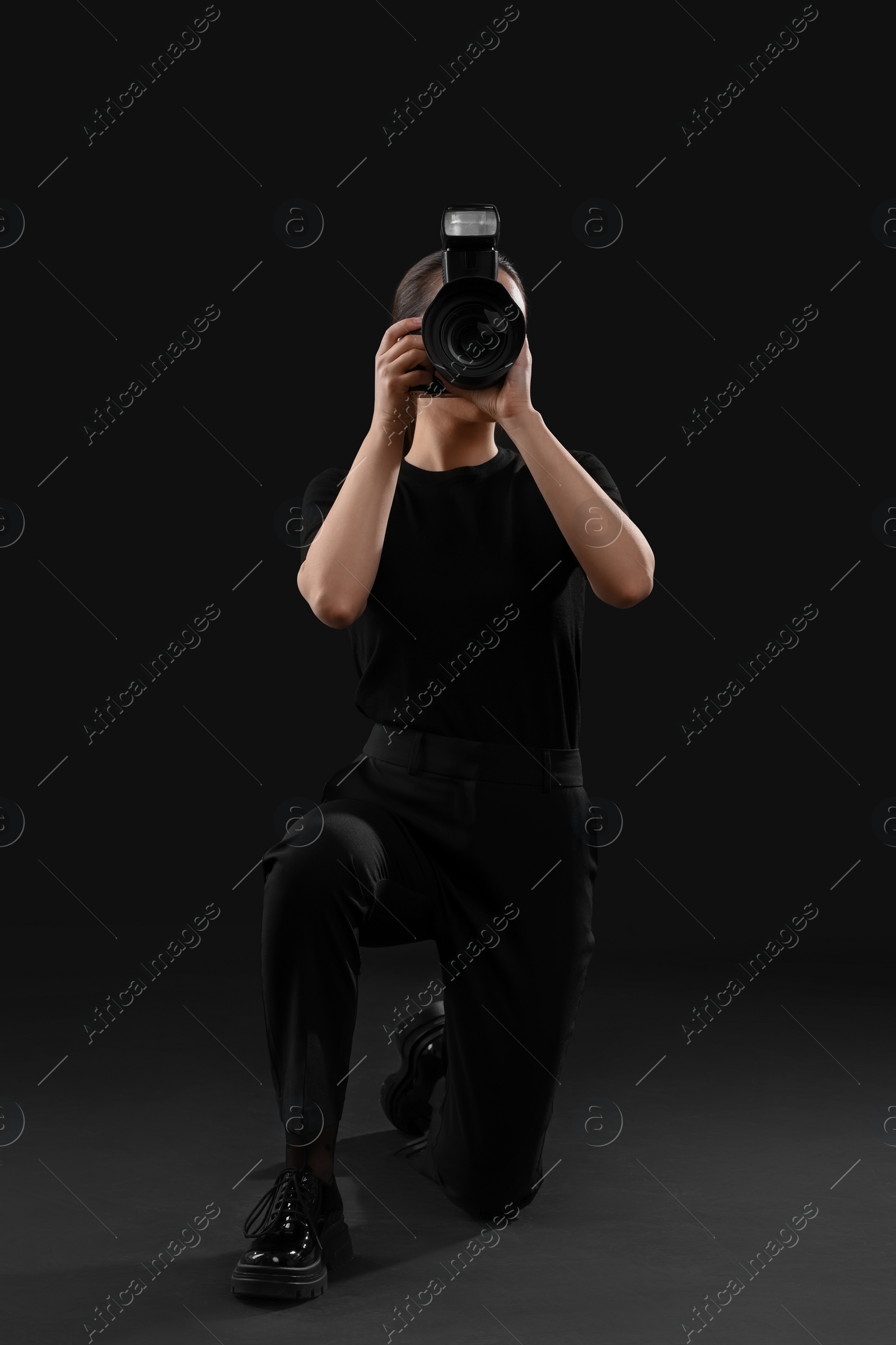 Photo of Professional photographer taking picture on black background