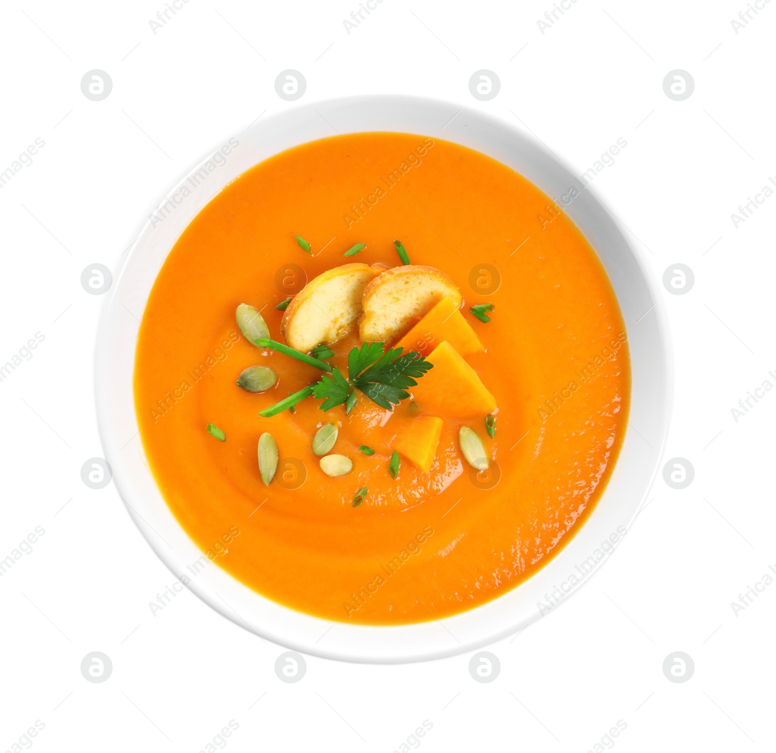 Photo of Dish with pumpkin cream soup on white background, top view. Healthy food