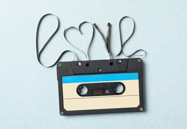Photo of Music cassette and word Love made with tape on turquoise background, top view. Romantic song