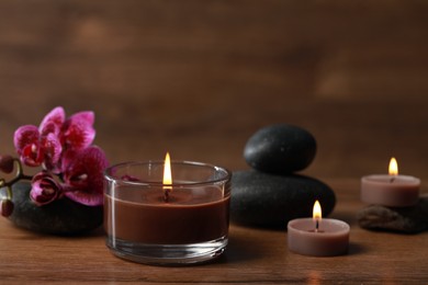 Beautiful spa composition with burning candles and flowers on wooden table