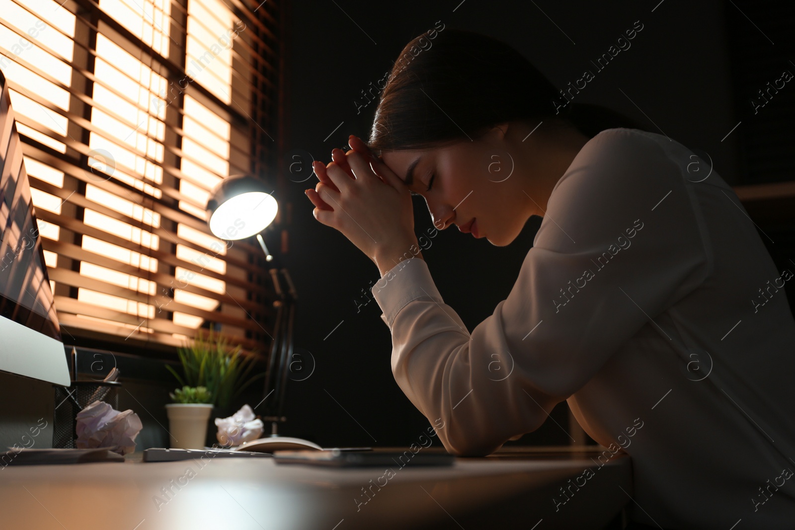 Photo of Businesswoman stressing out at workplace late in evening