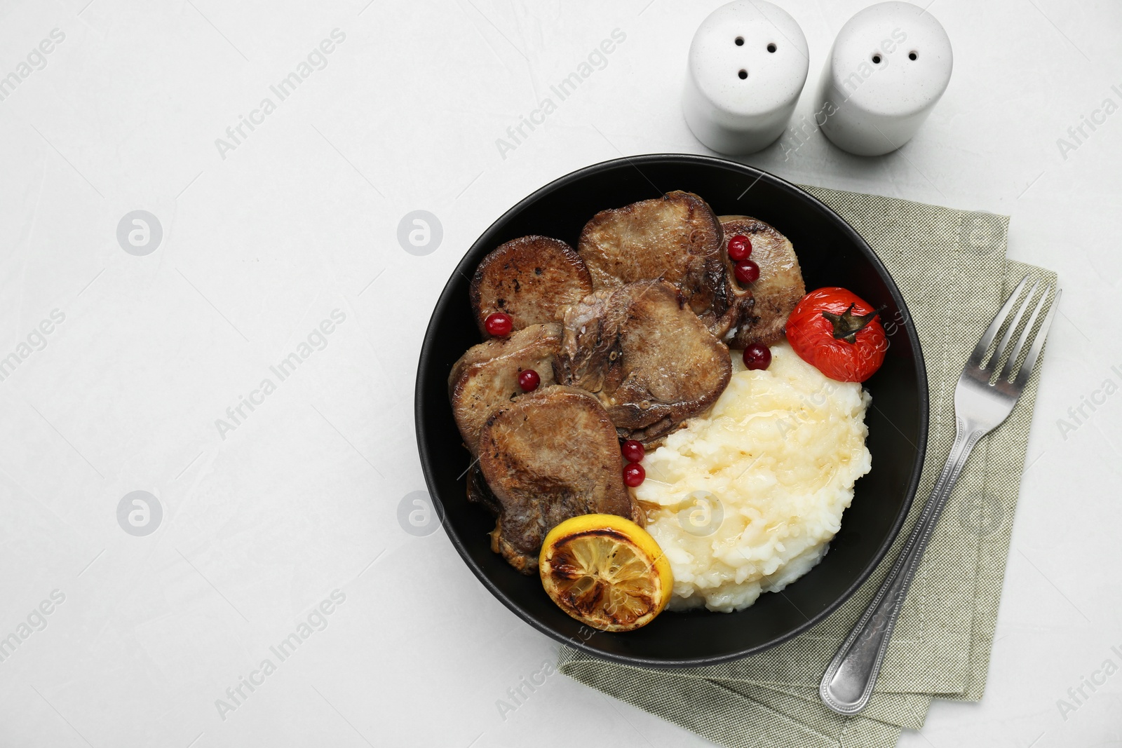 Photo of Tasty beef tongue pieces, berries, lemon, tomato and mashed potatoes on white table, flat lay. Space for text