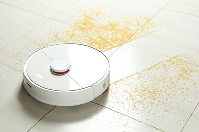 Photo of Robot vacuum cleaner removing dirt from floor in room