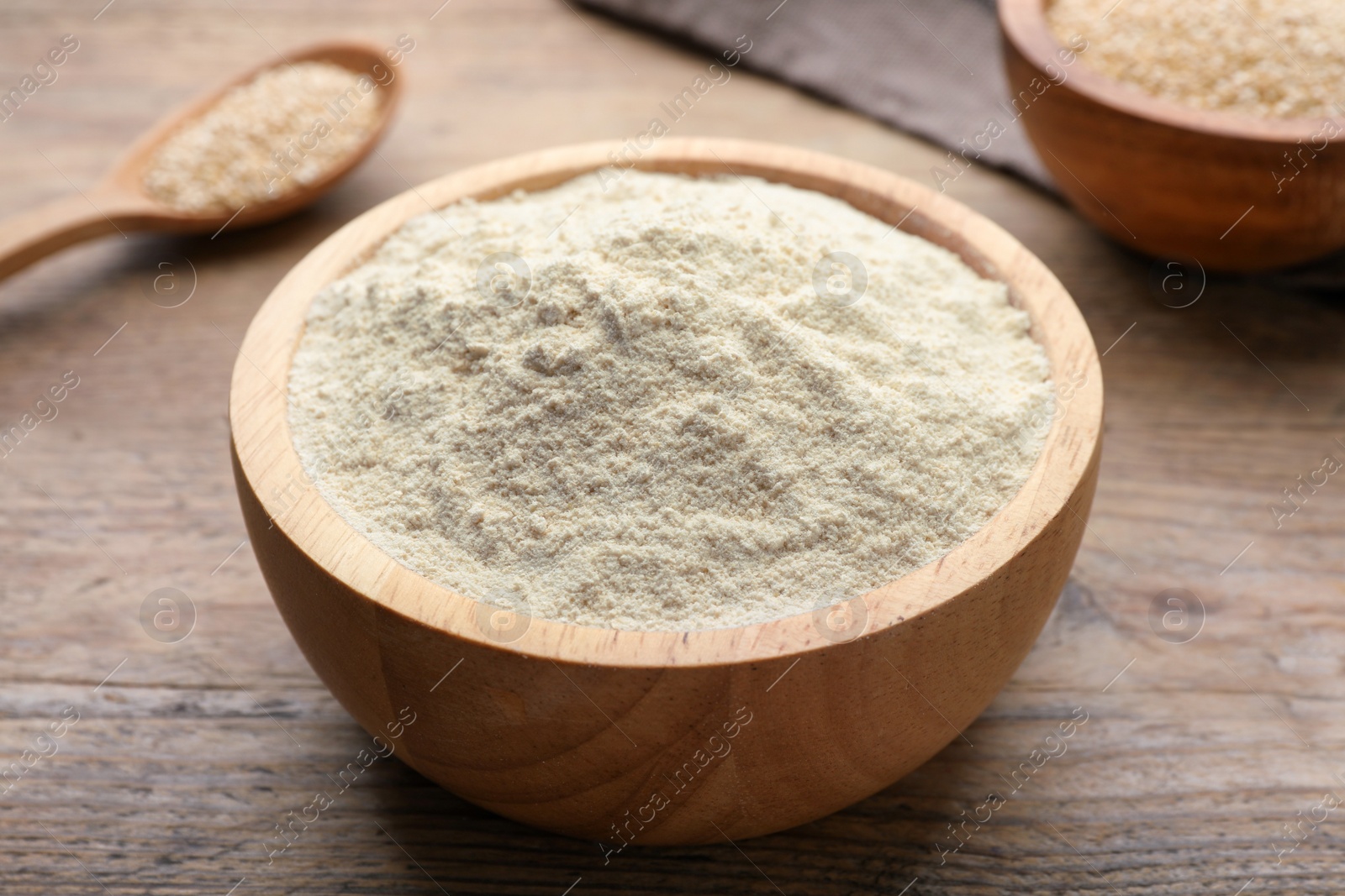 Photo of Quinoa flour in bowl on wooden table