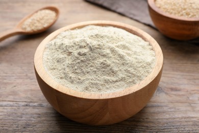 Quinoa flour in bowl on wooden table