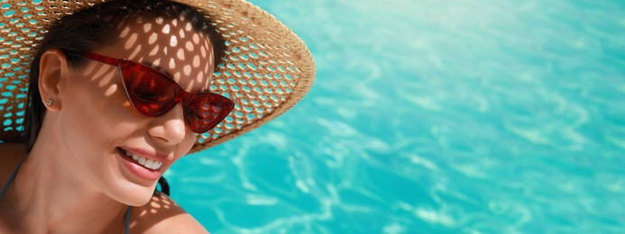 Beautiful woman with hat and sunglasses in swimming pool on sunny day, banner design
