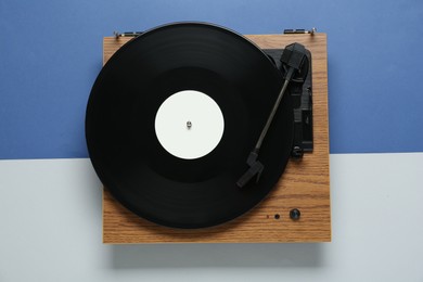 Photo of Turntable with vinyl record on color background, top view