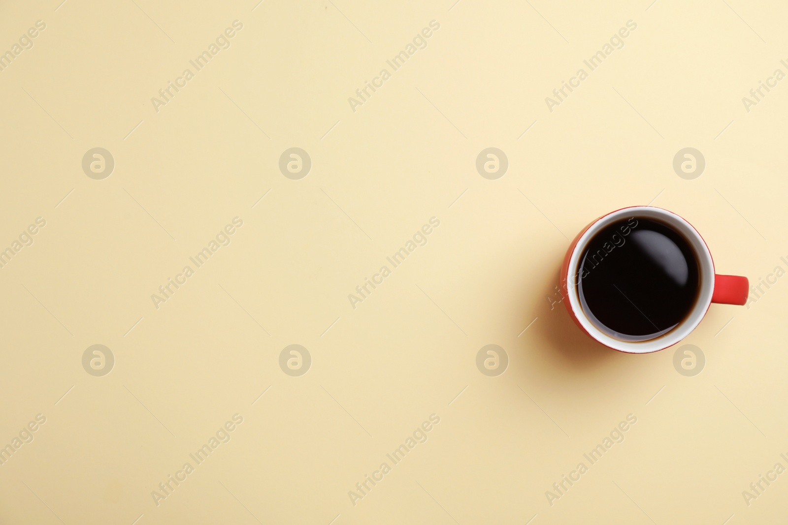 Photo of Ceramic cup with hot aromatic coffee on color background, top view