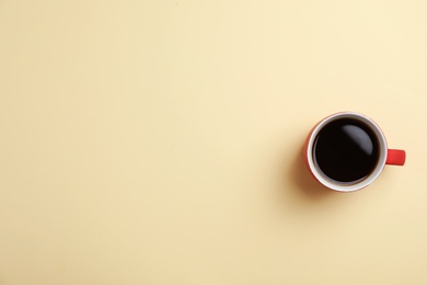 Ceramic cup with hot aromatic coffee on color background, top view