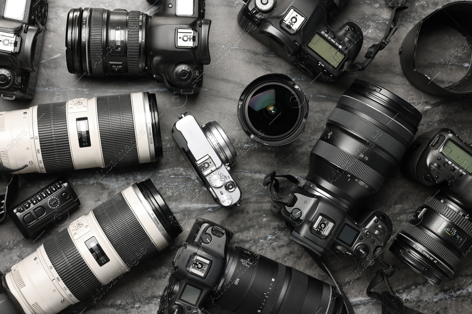 Photo of Modern cameras on dark gray marble table, flat lay