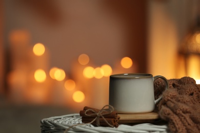 Cup of tea on table against blurred lights, space for text. Cozy winter