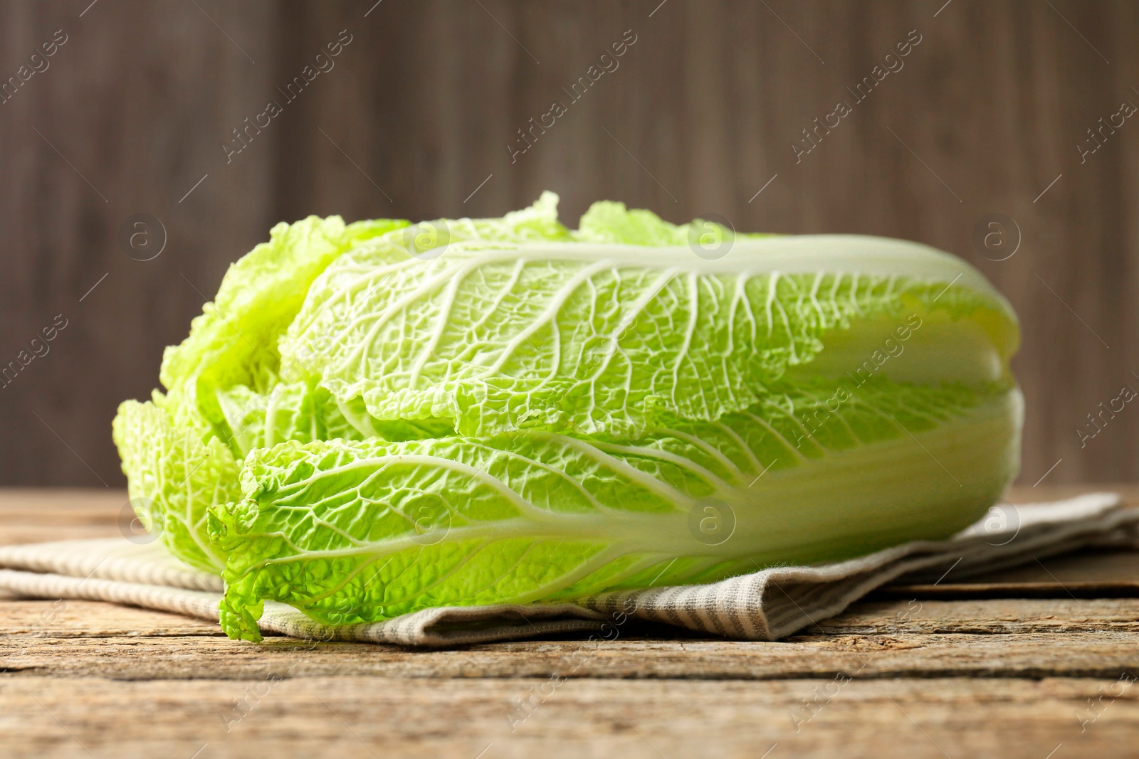 Photo of Fresh ripe Chinese cabbage on wooden table, closeup