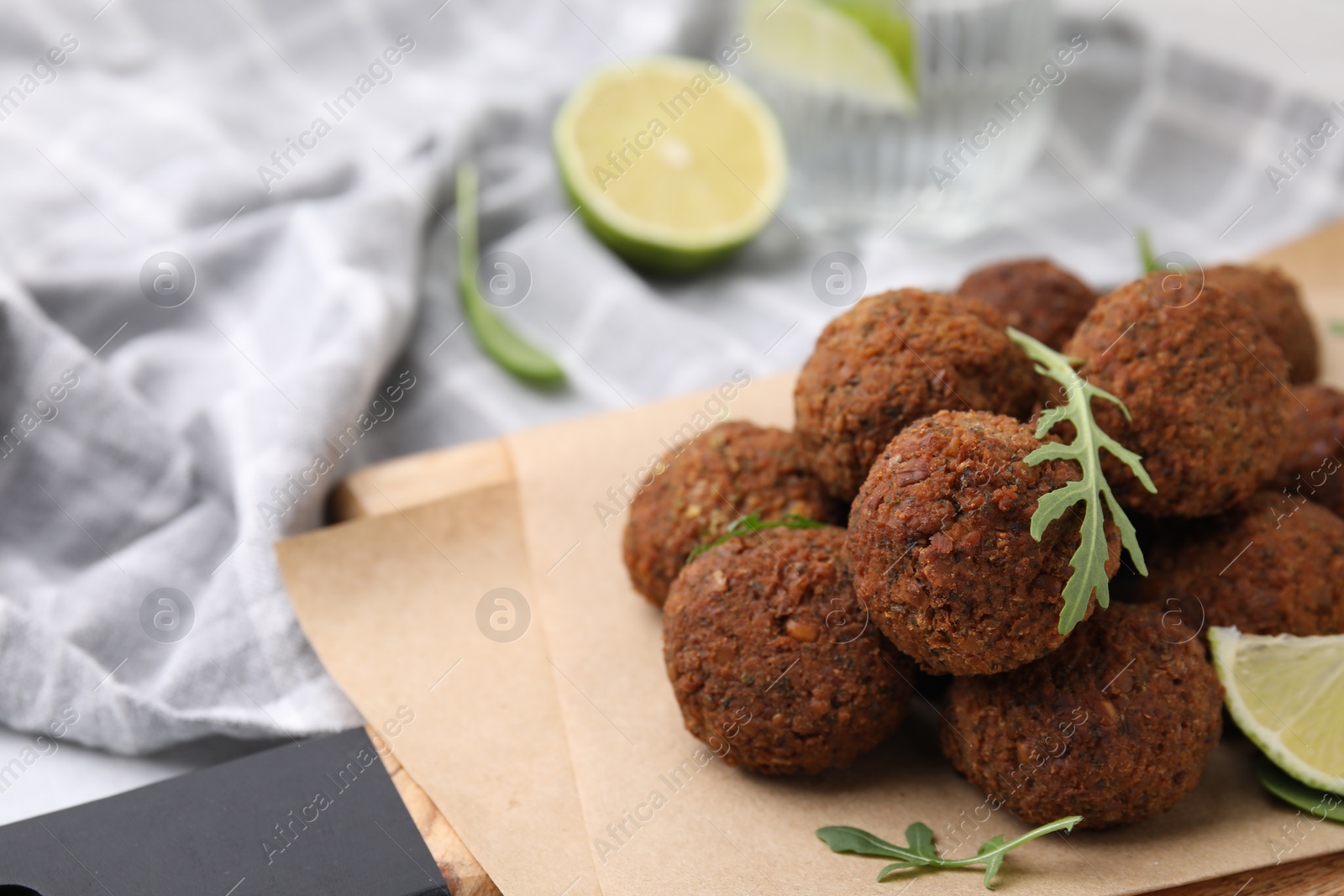 Photo of Delicious falafel balls and arugula on table, closeup. Space for text