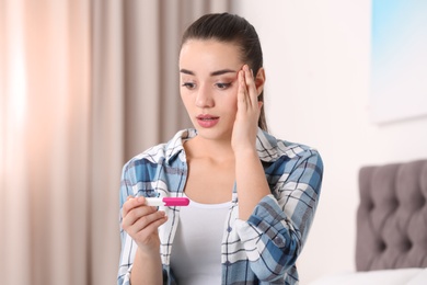 Photo of Young woman with pregnancy test at home. Gynecology and childbirth