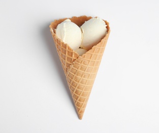 Delicious vanilla ice cream in wafer cone on white background, top view