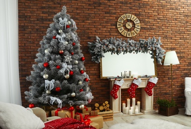 Stylish interior with beautiful Christmas tree and decorative fireplace