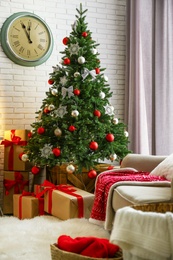 Photo of Stylish interior with beautiful Christmas tree and gift boxes