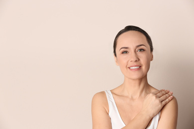 Portrait of beautiful mature woman on beige background. Space for text