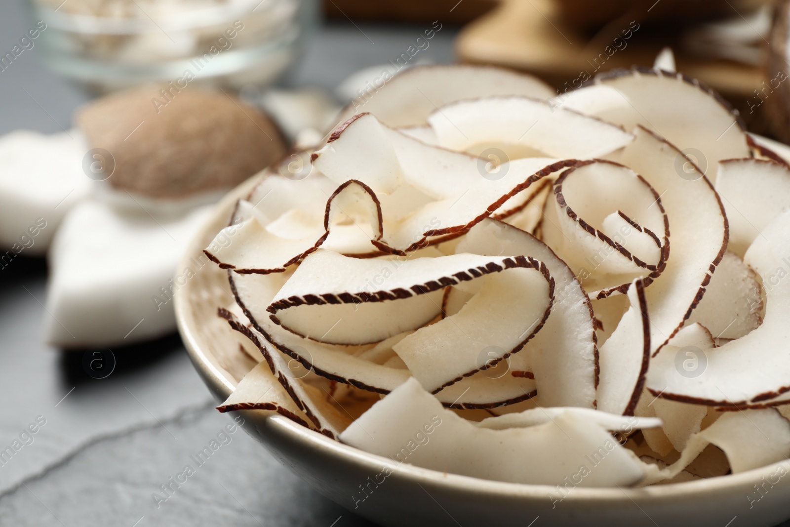 Photo of Tasty organic coconut chips in bowl, closeup