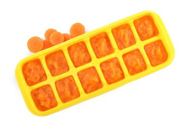 Photo of Carrot puree in ice cube tray on white background, top view. Ready for freezing