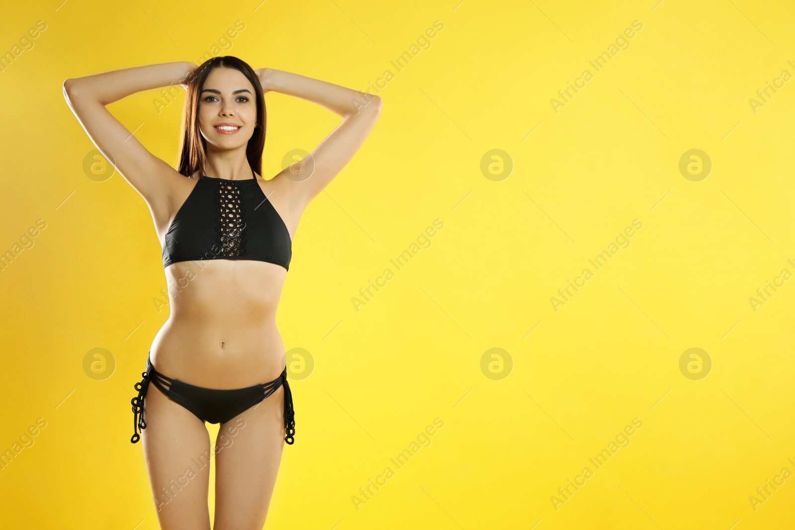 Photo of Portrait of attractive young woman with slim body in swimwear on color background. Space for text