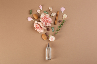 Photo of Flat lay composition with bottle of perfume on light brown background