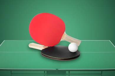 Paddles and ball on ping pong table against green background
