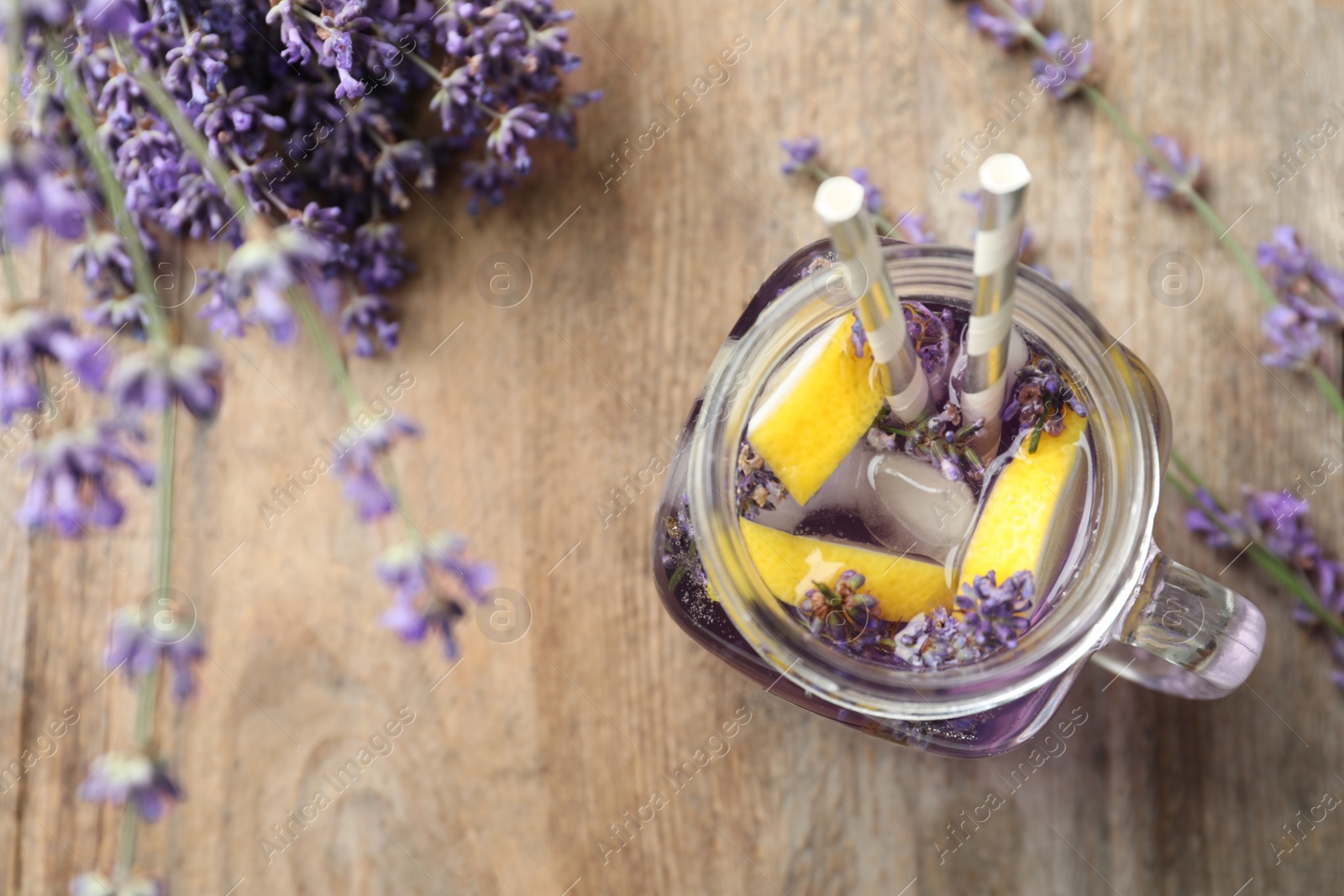 Photo of Fresh delicious lemonade with lavender in masson jar on wooden table, top view