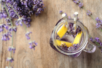 Fresh delicious lemonade with lavender in masson jar on wooden table, top view