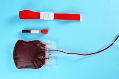 Flat lay composition with blood pack and test tube on color background. Donation day