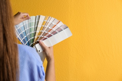 Photo of Female interior designer with palette samples on color background, closeup. Space for text