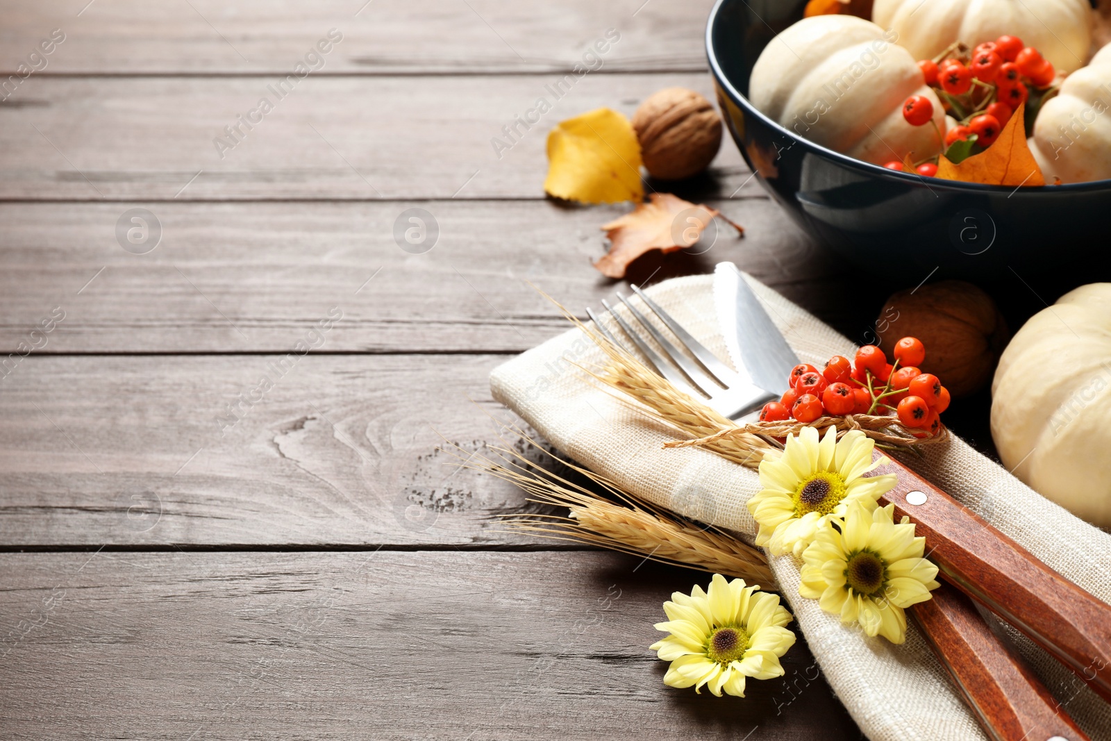 Photo of Festive table setting with autumn decor and space for text on wooden background, closeup. Thanksgiving Day celebration