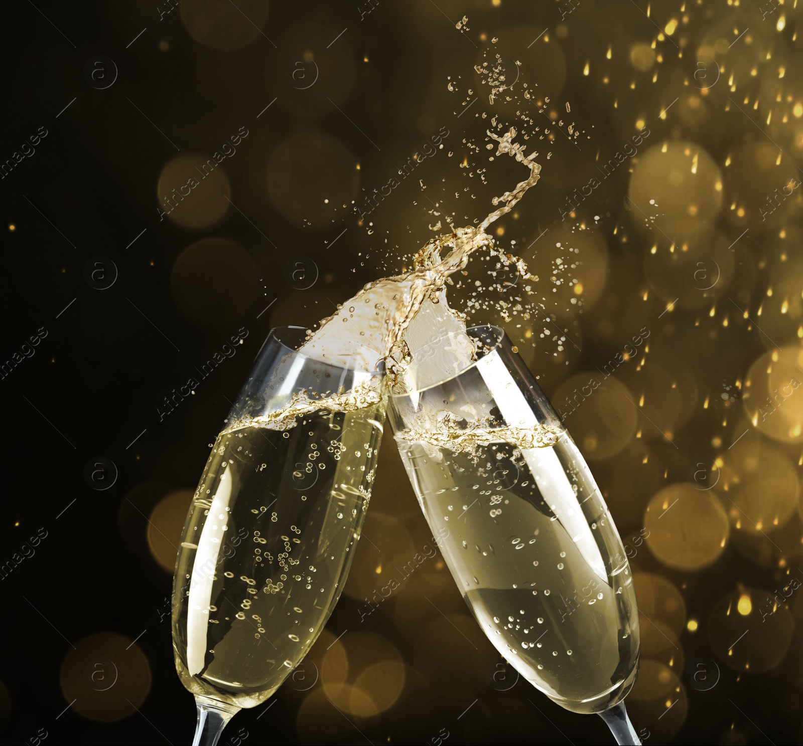 Image of Clinking glasses of sparkling wine with splash on black background. Bokeh effect