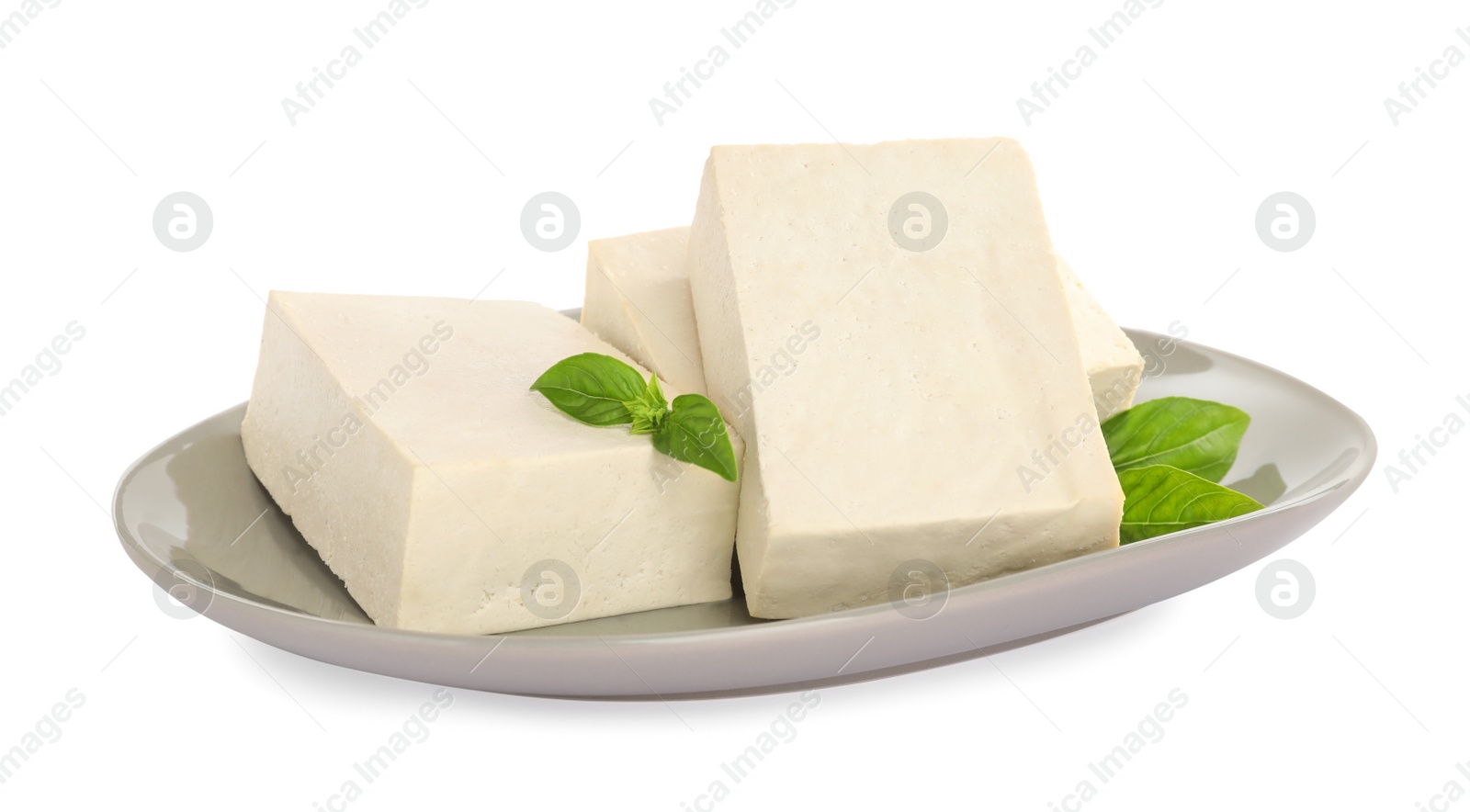 Photo of Plate with delicious raw tofu and basil isolated on white