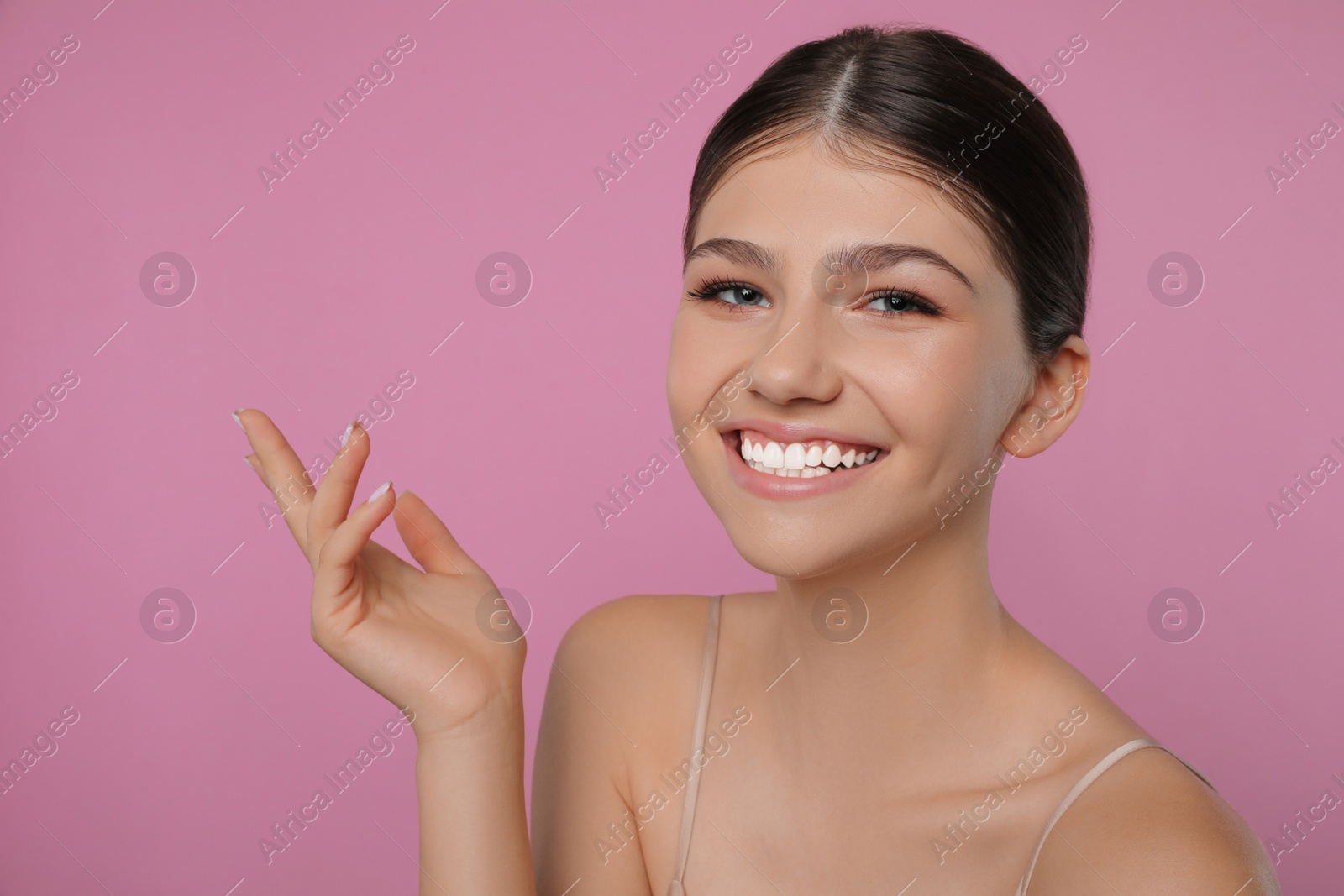 Photo of Portrait of pretty girl on pink background. Beautiful face with perfect smooth skin