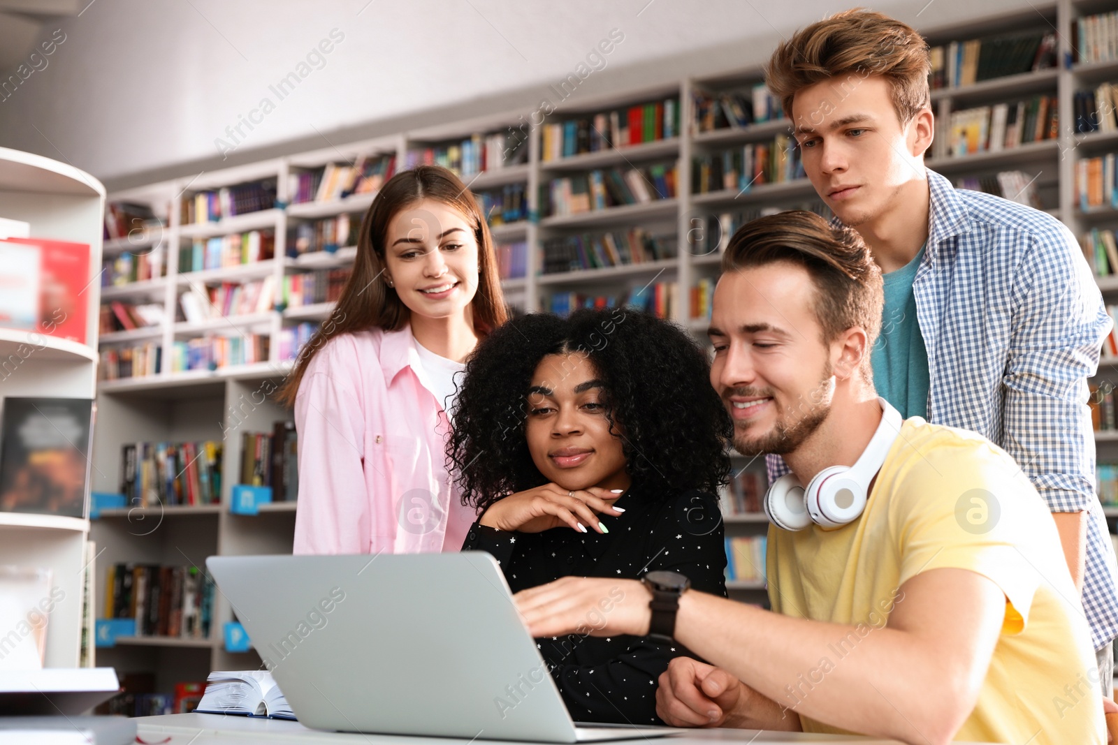 Photo of Group of young people studying at table in library