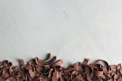 Photo of Chocolate curls and space for text on gray background, top view