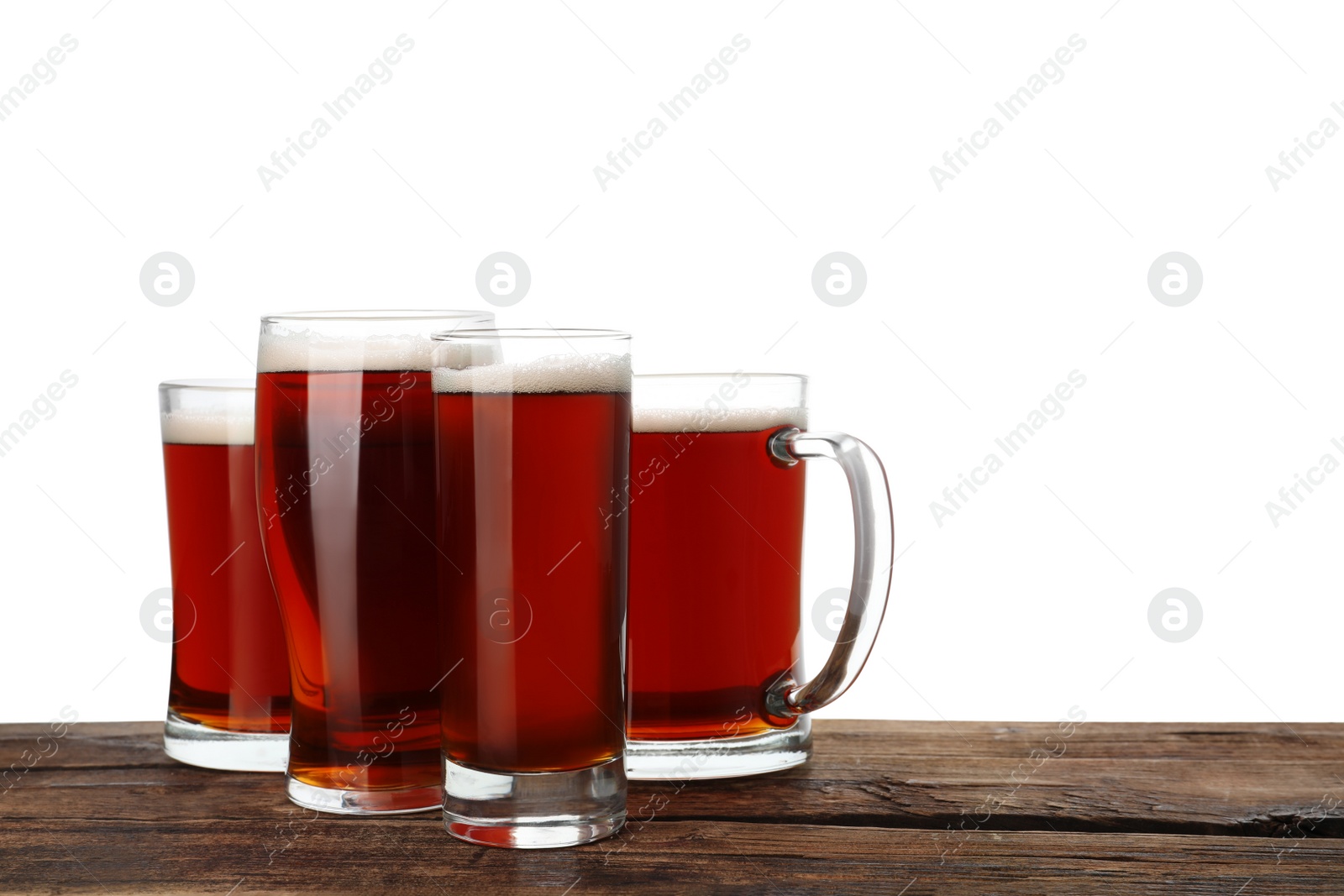 Photo of Glasses of delicious kvass on wooden table, white background