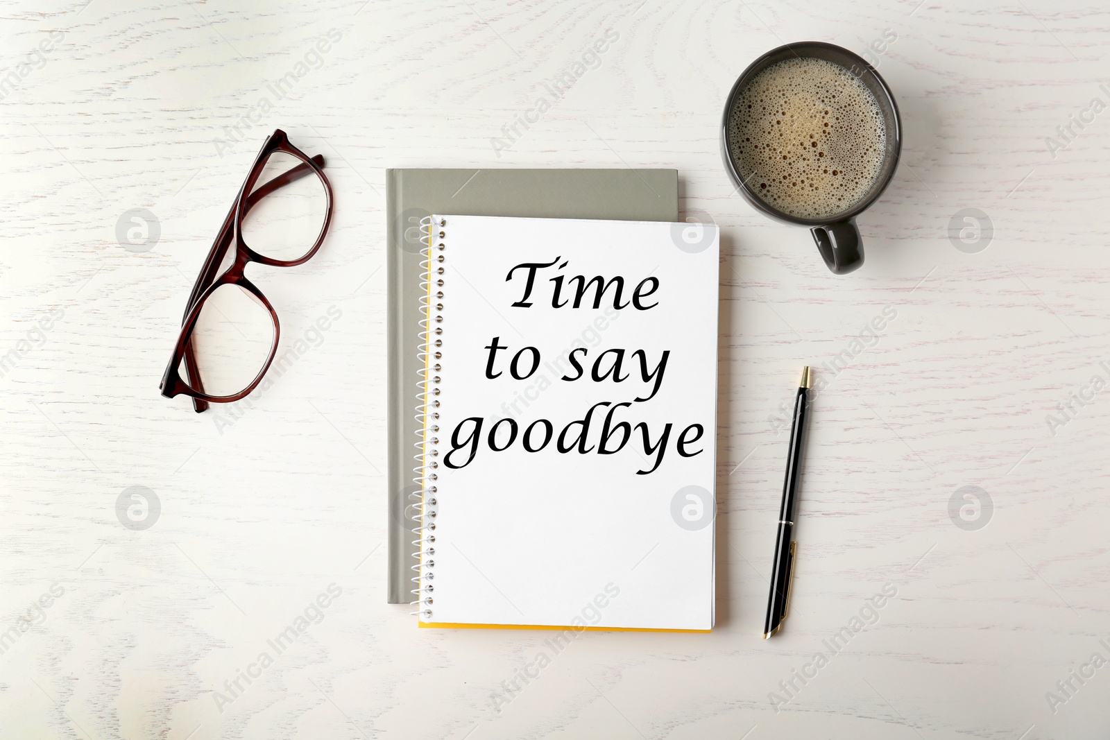 Image of Notebook with text Time to say goodbye, office stationery and cup of coffee on white wooden table, flat lay