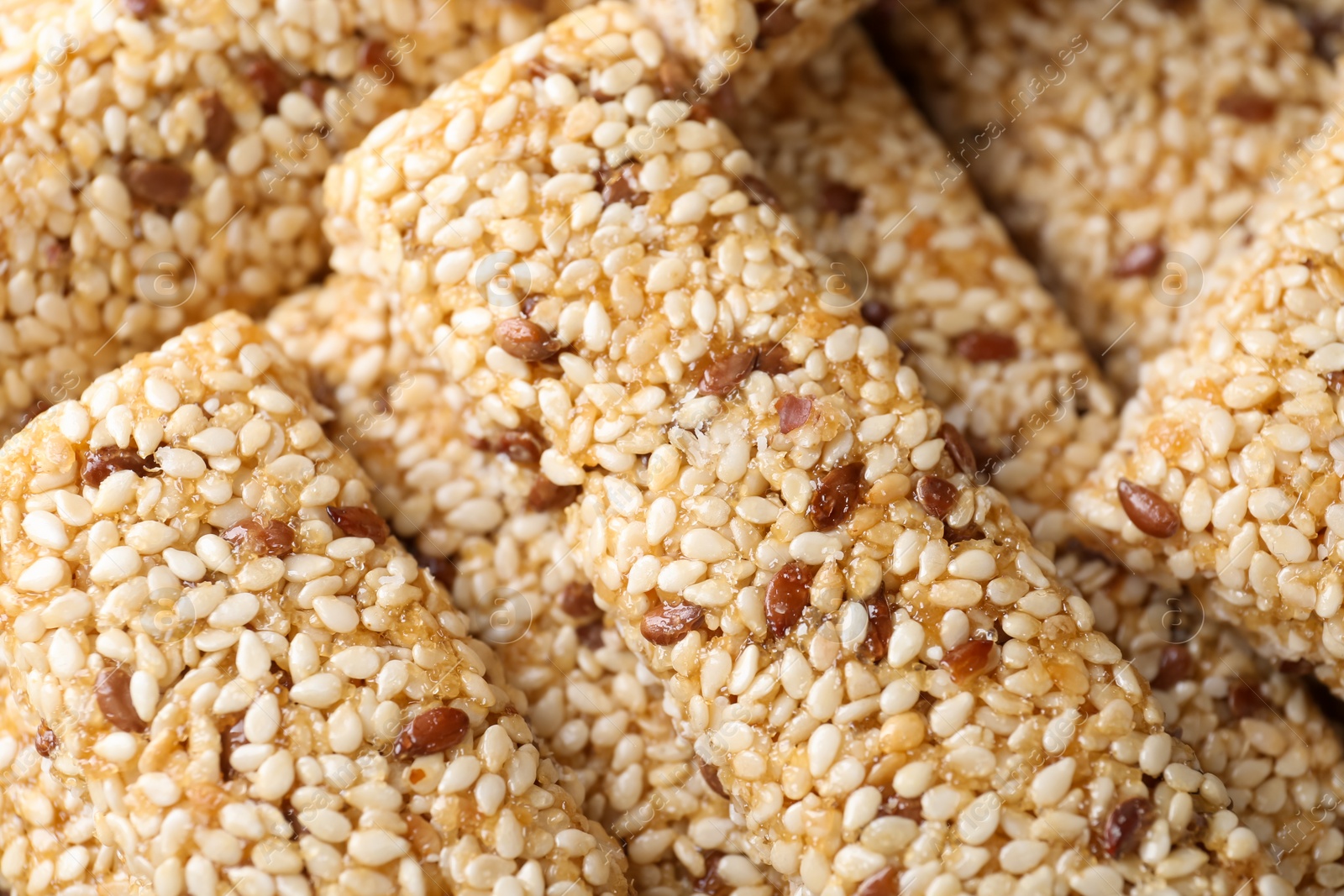 Photo of Tasty sesame seed bars as background, top view