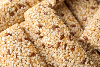 Tasty sesame seed bars as background, top view