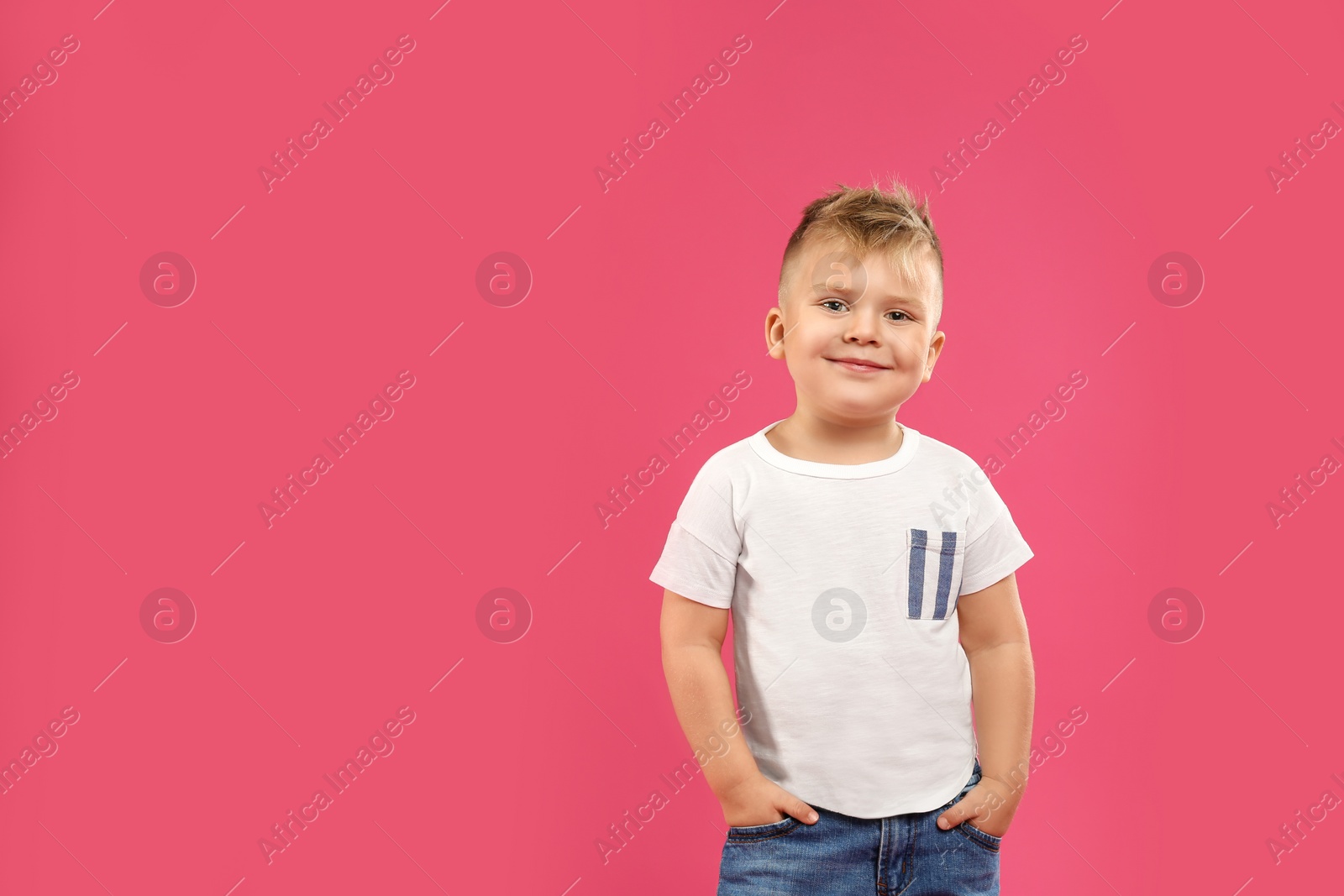 Photo of Cute little boy posing on pink background.  Space for text