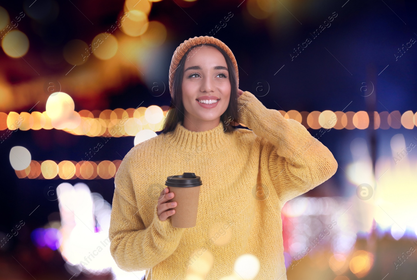 Image of Happy beautiful woman with paper cup of mulled wine at Christmas fair