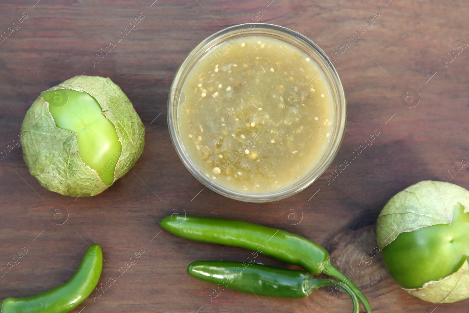 Photo of Tasty salsa sauce and ingredients on wooden table, flat lay