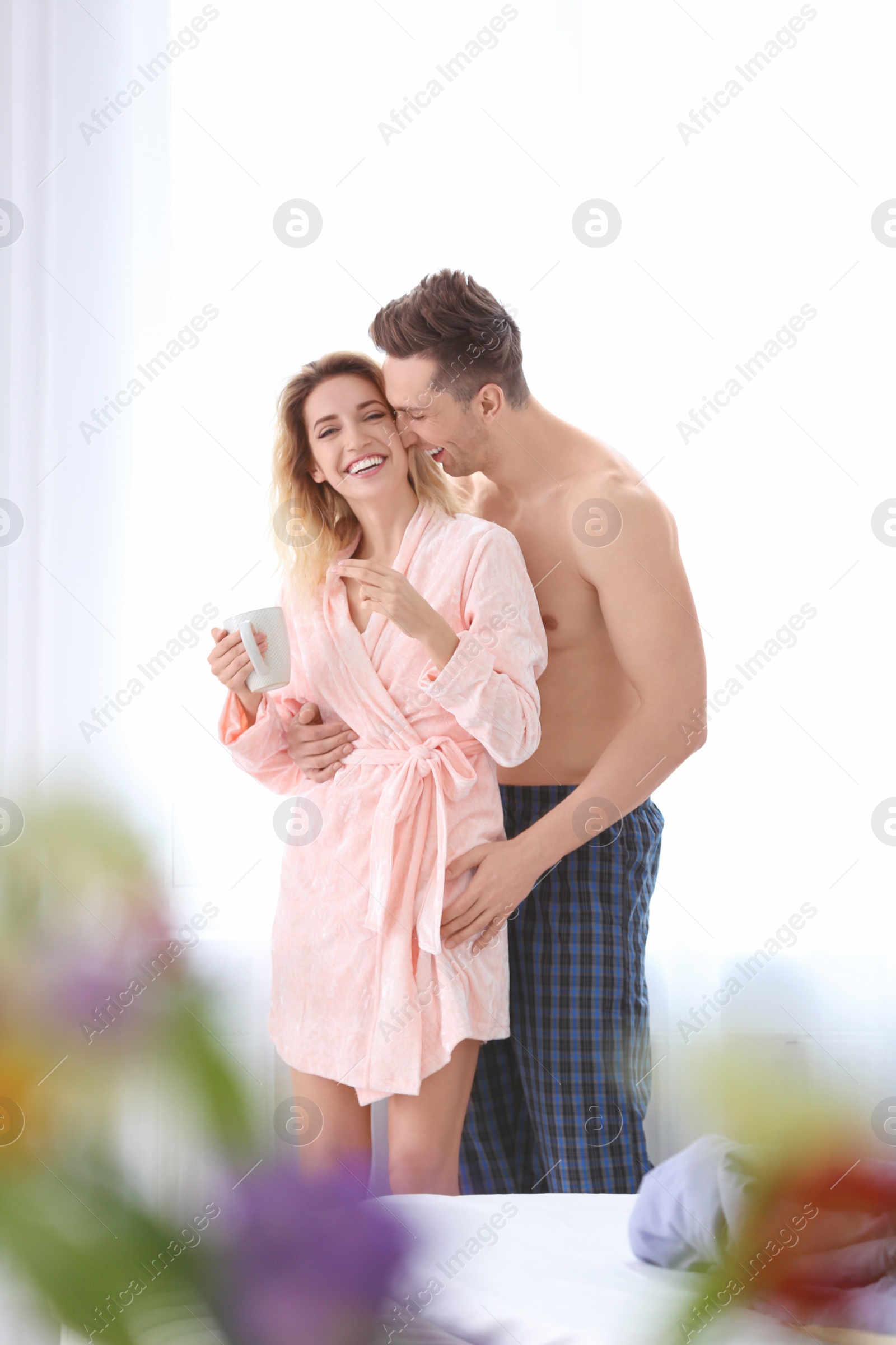 Photo of Lovely young couple hugging in bedroom