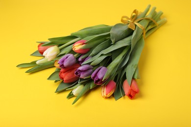 Bunch of beautiful tulips on yellow background