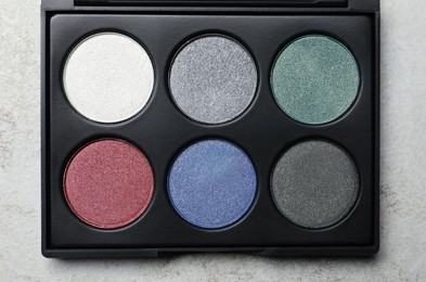 Photo of Beautiful eye shadow palette on grey table, top view