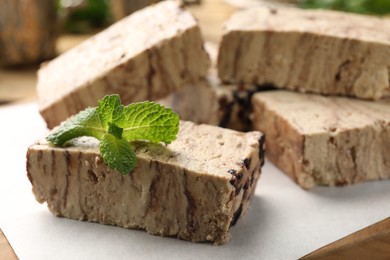 Photo of Tasty chocolate halva with mint on board, closeup